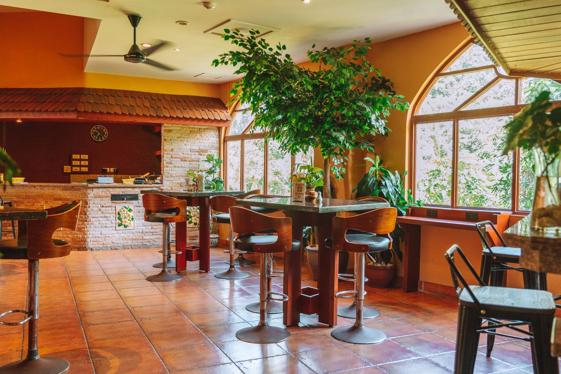 A restaurant with tables and chairs and a tree in the middle