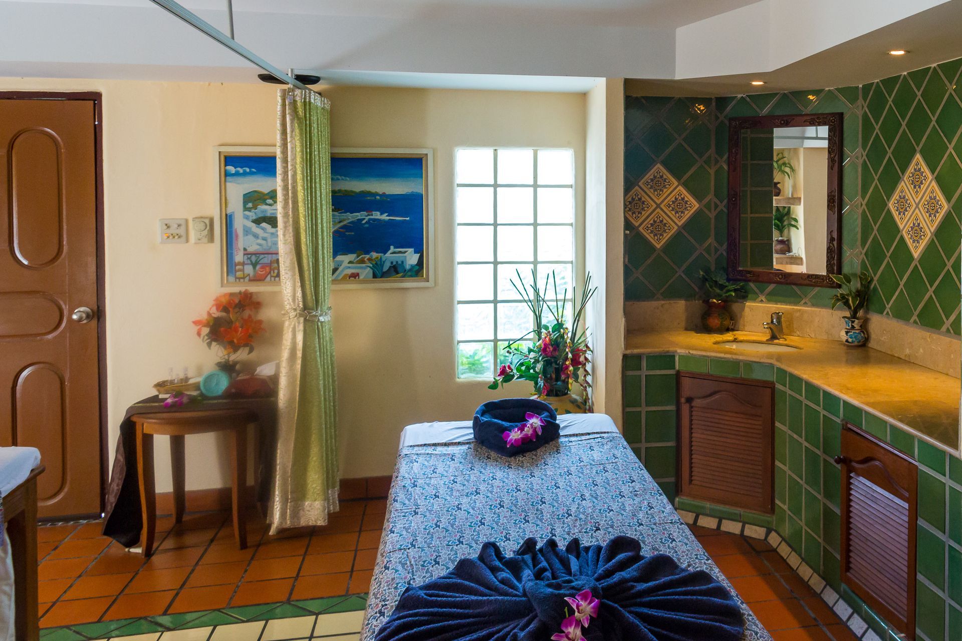 A room with a massage table and a mirror