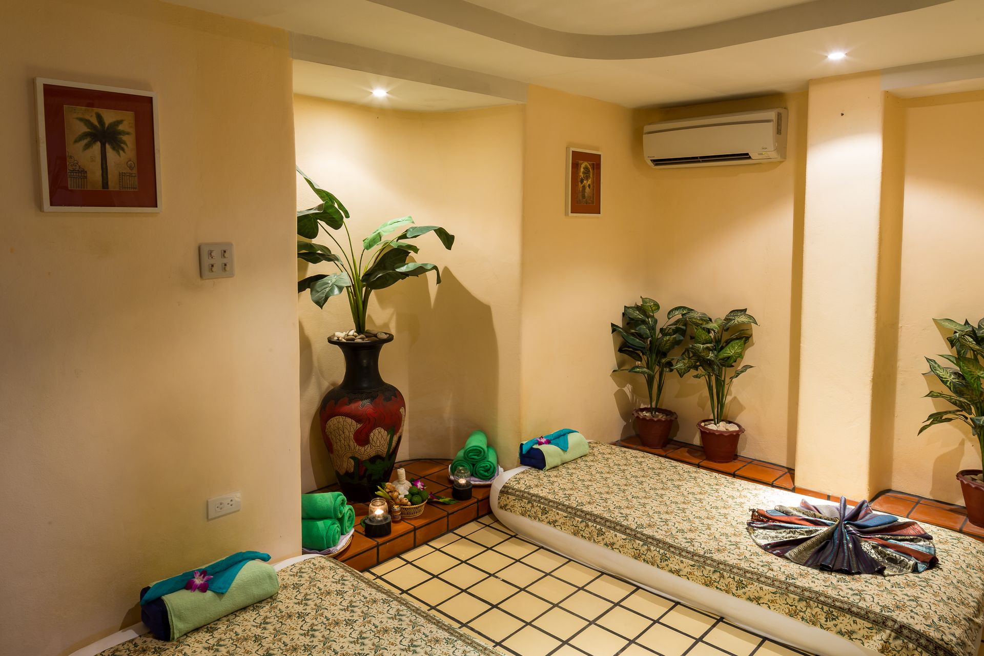A room with two beds and a vase on the wall