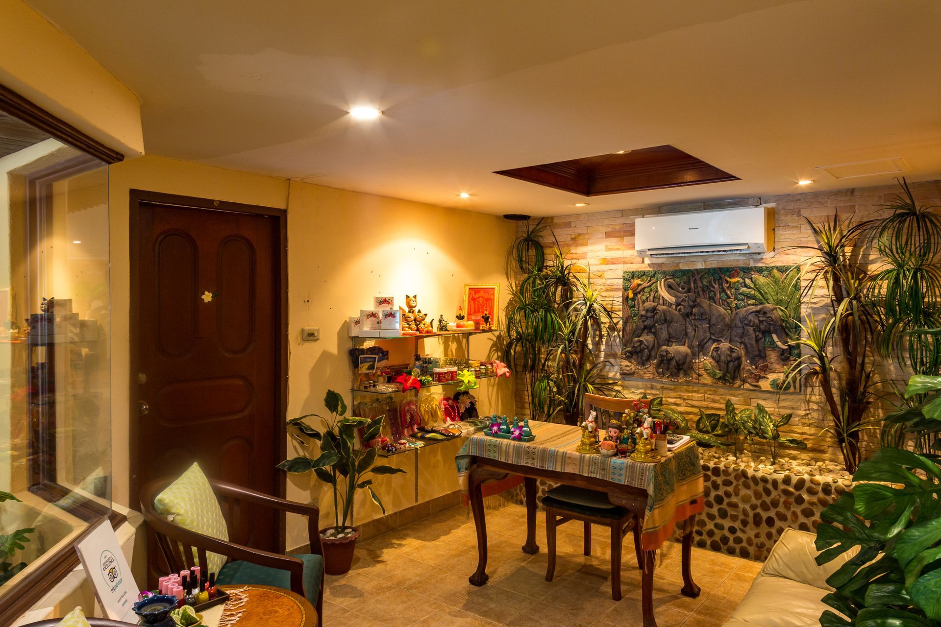 A living room with a table and chairs and plants.
