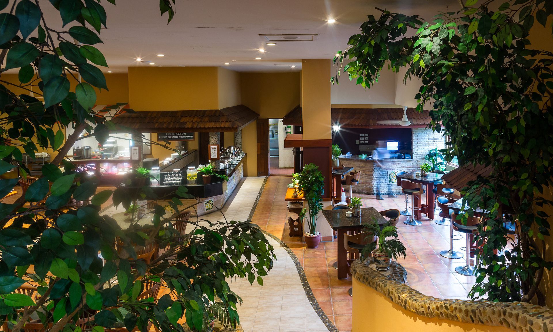 A restaurant with tables and chairs surrounded by trees
