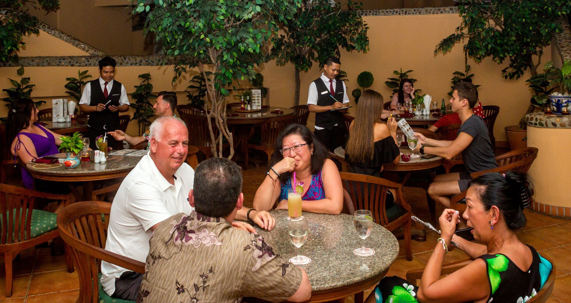 A group of people are sitting at tables in a restaurant.