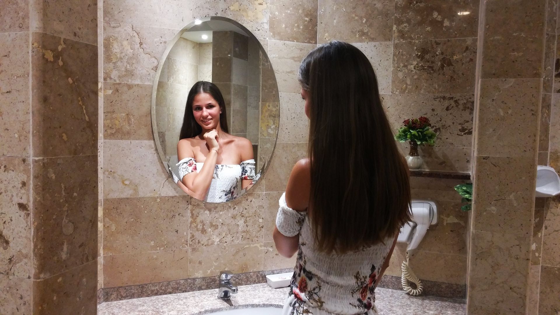 A hotel room with a large bed , desk , chair and television.