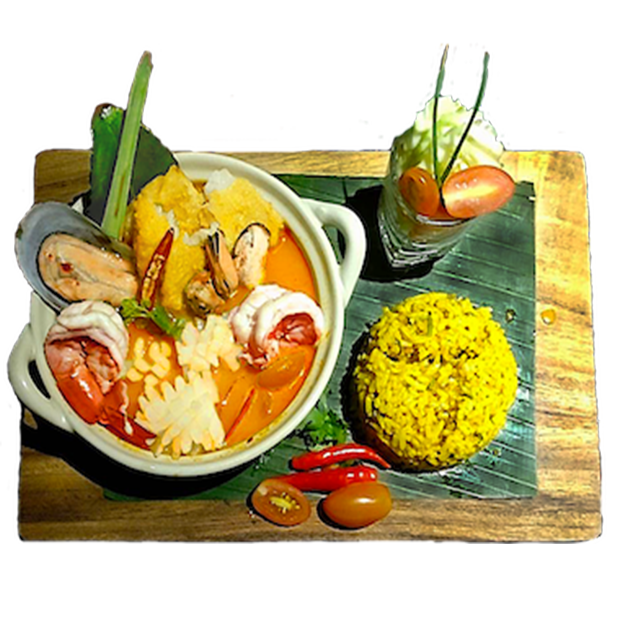 A bowl of food with rice and tomatoes on a wooden cutting board