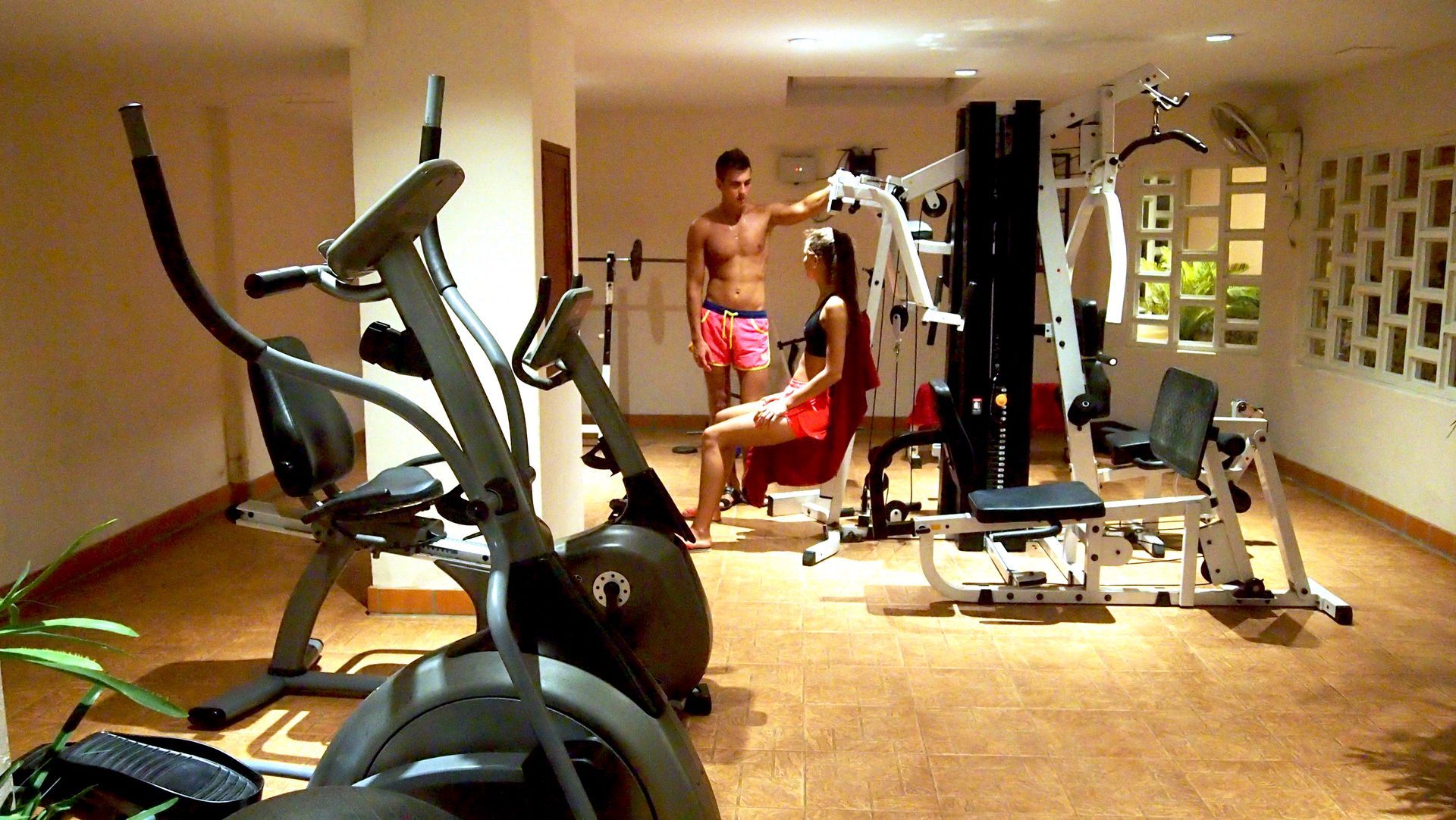 A man and a woman are working out in a gym