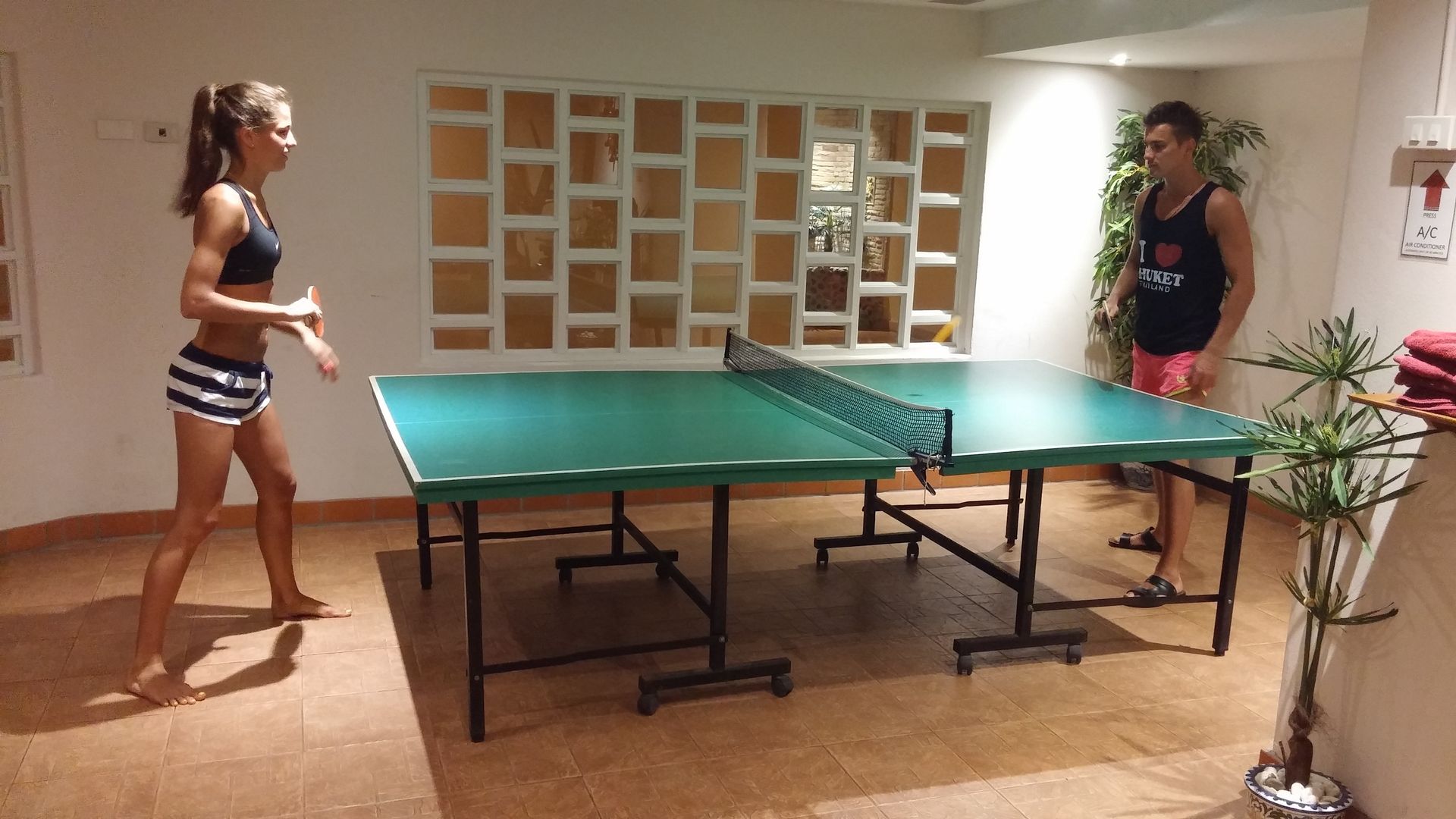 A man and a woman are playing ping pong on a table