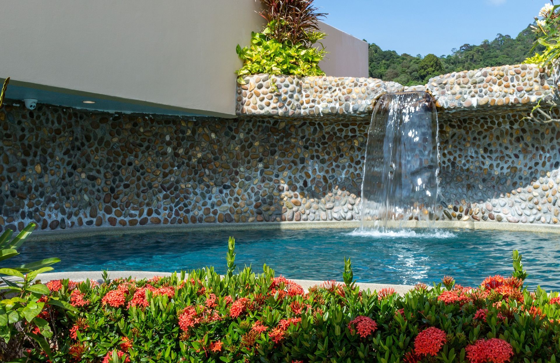 A swimming pool with a waterfall in the background