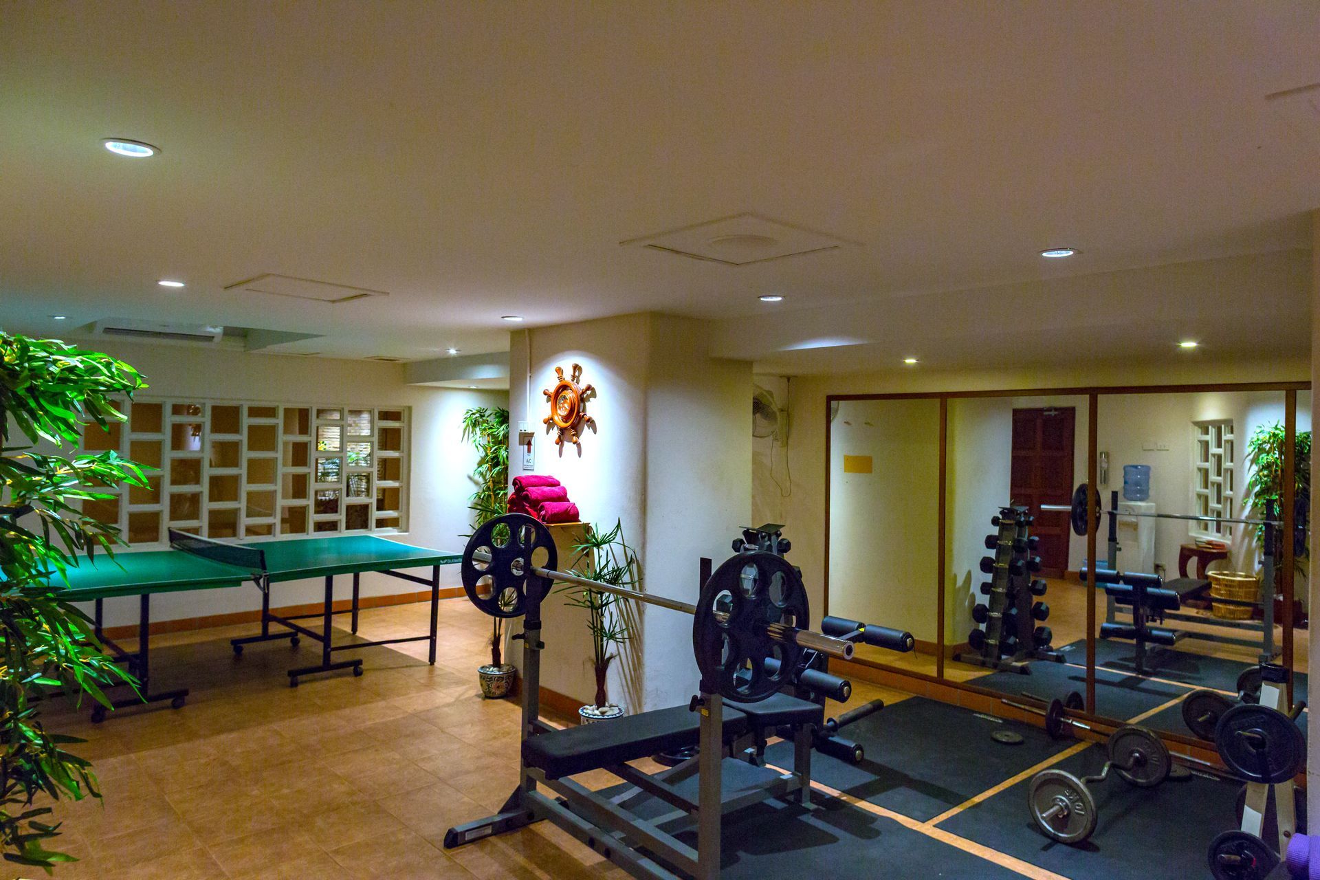 A gym with a ping pong table and a barbell
