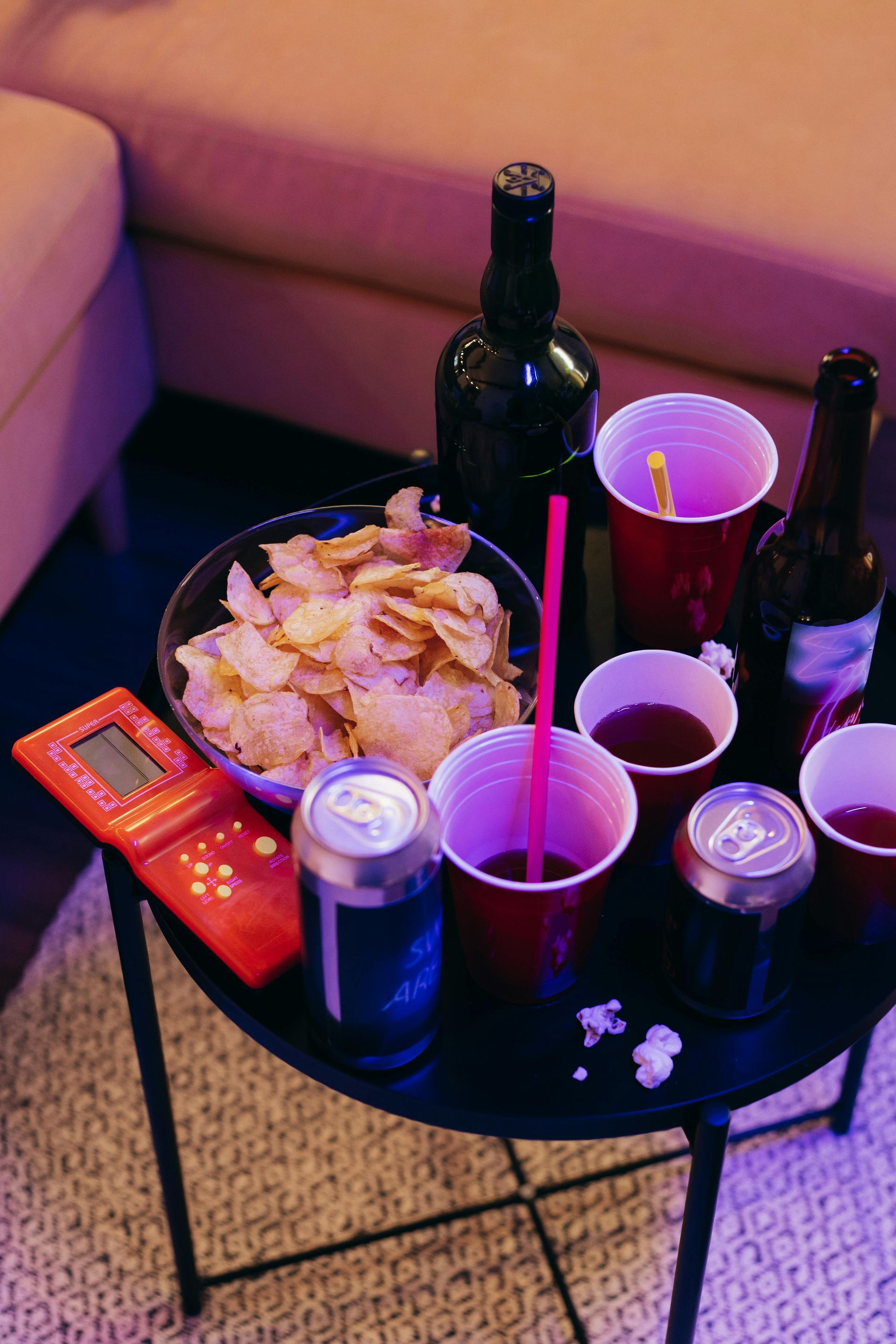 A small table with snacks, drinks, and a game console.
