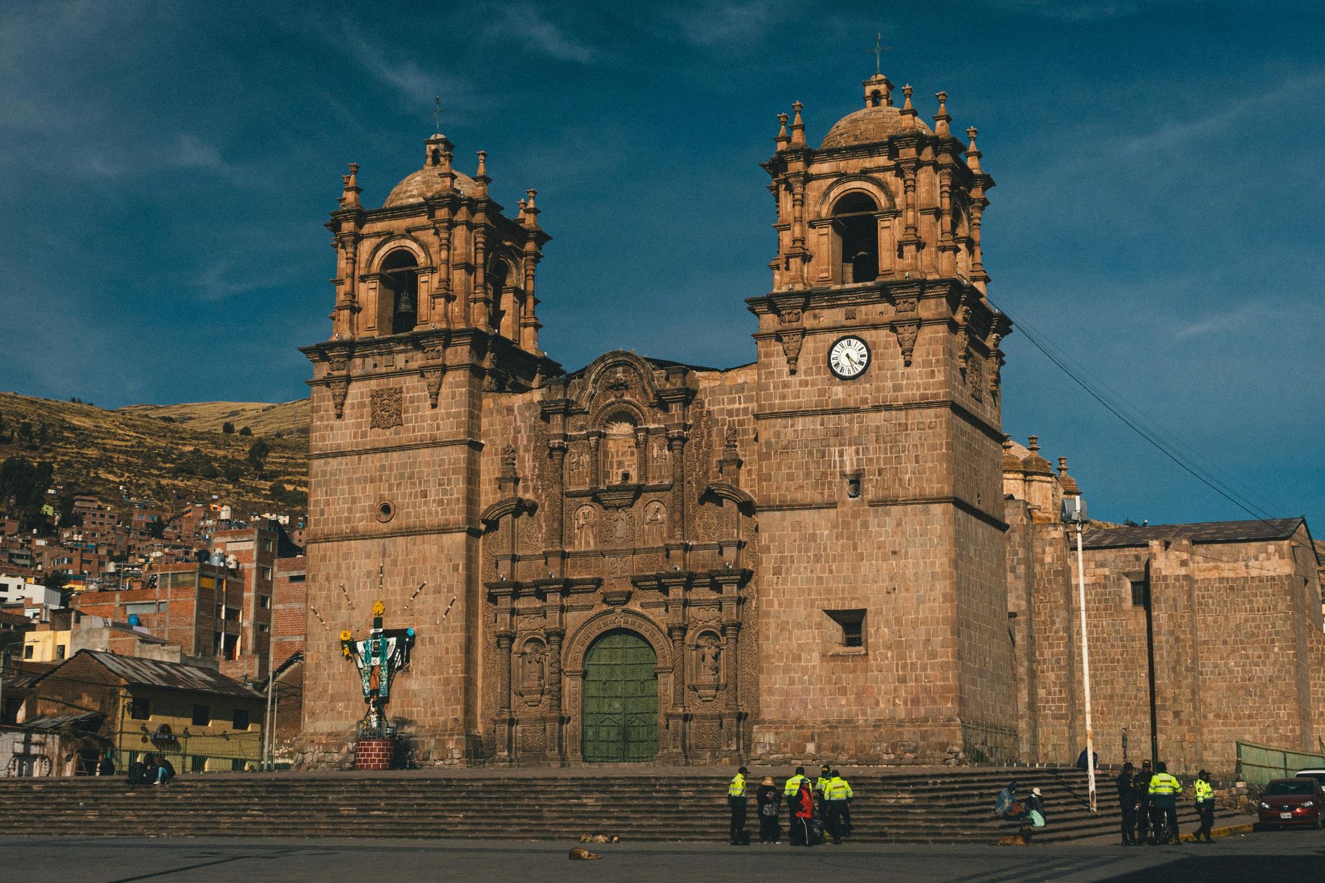 Una catedral de piedra con dos torres y una puerta central arqueada de color verde.