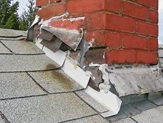 A brick chimney is sitting on top of a roof