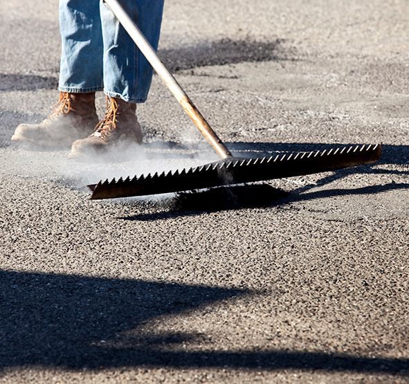 a person patching a driveway