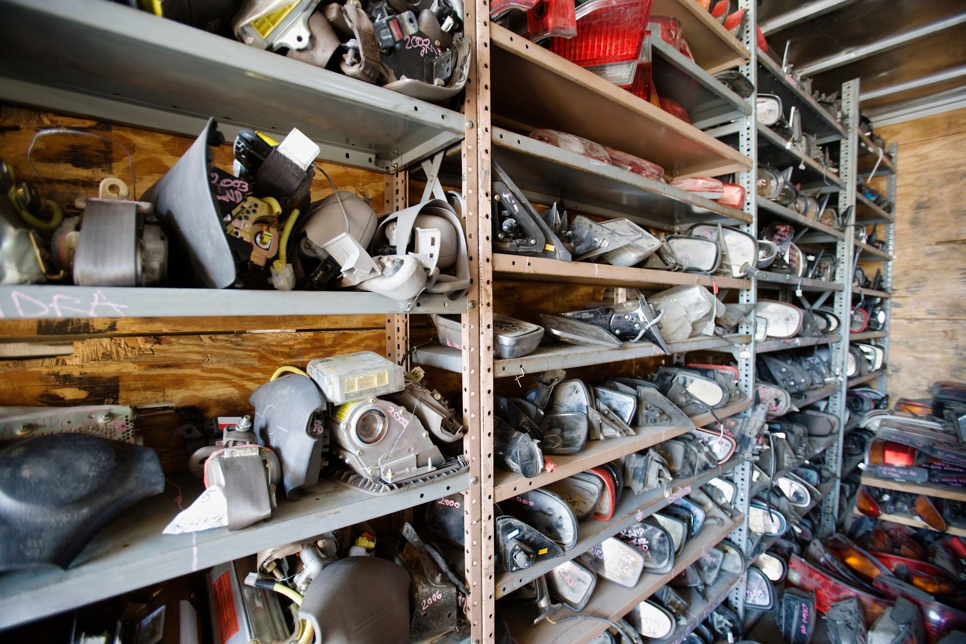 Shelves filled with various car parts in a storage room.