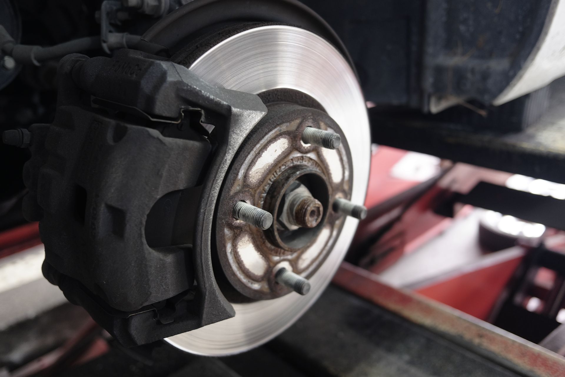 Car brake disc and caliper assembly, showing a silver disc and black caliper.