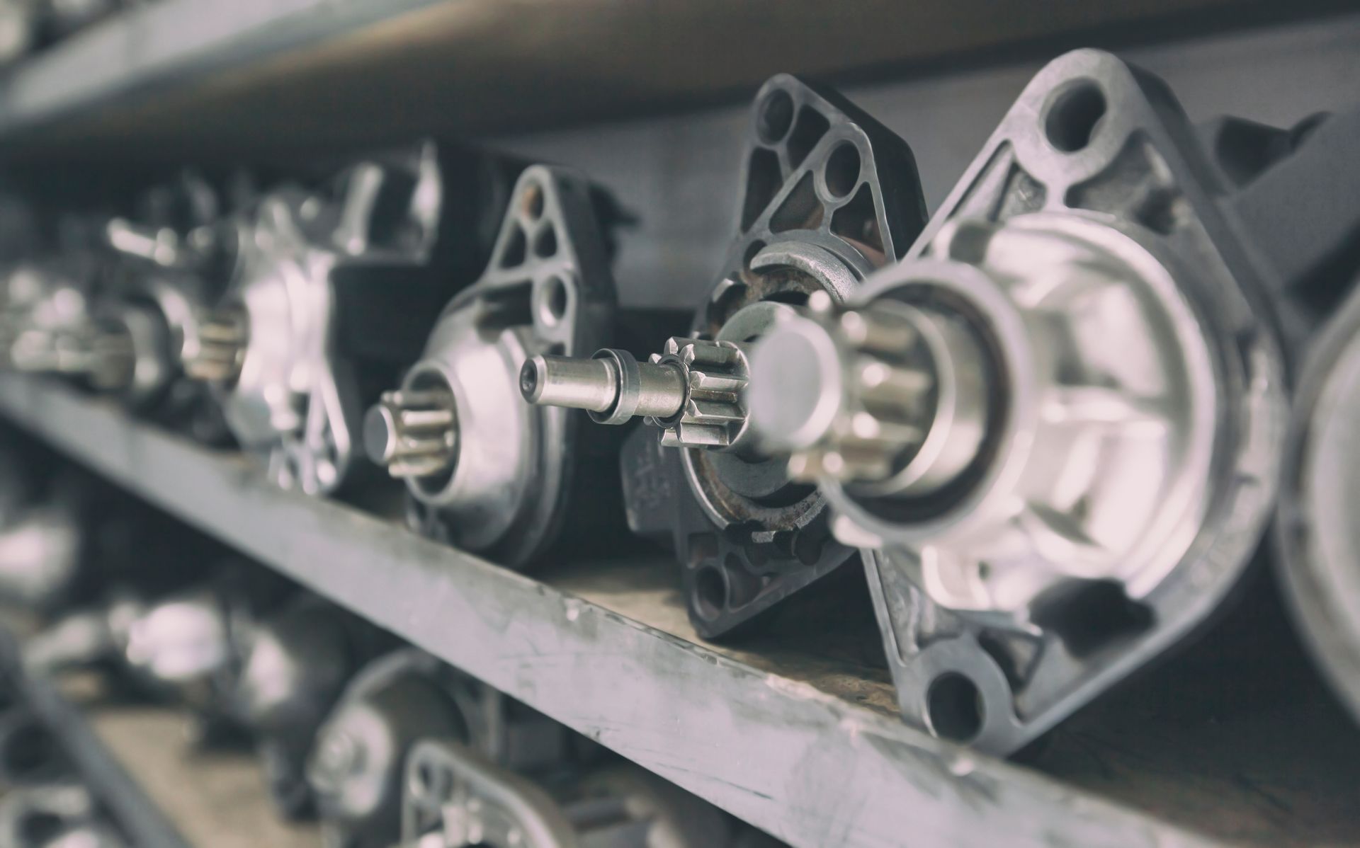 Starters lined up on a shelf in a parts warehouse.
