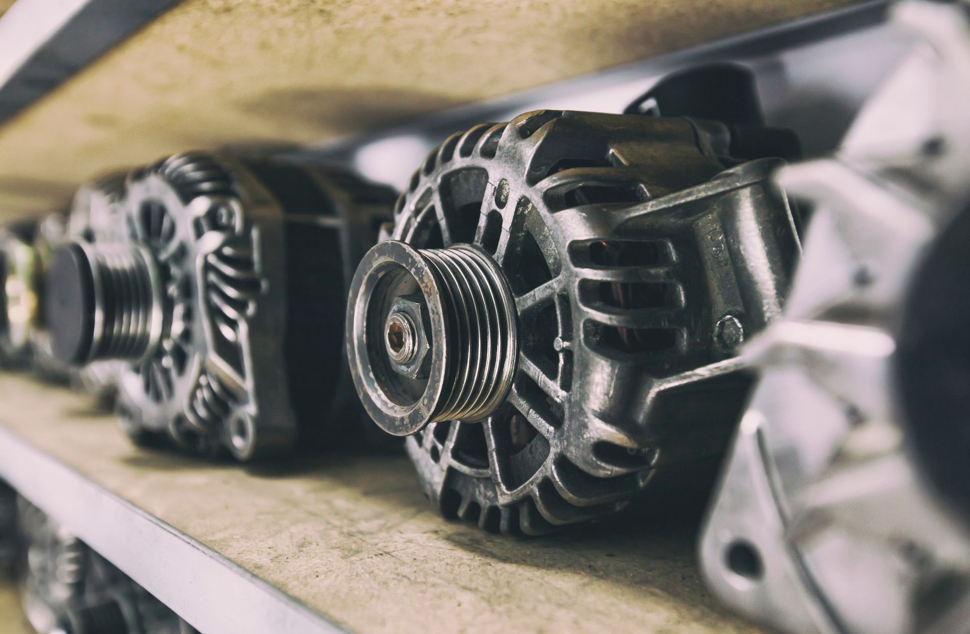Alternators on a shelf, various designs visible.