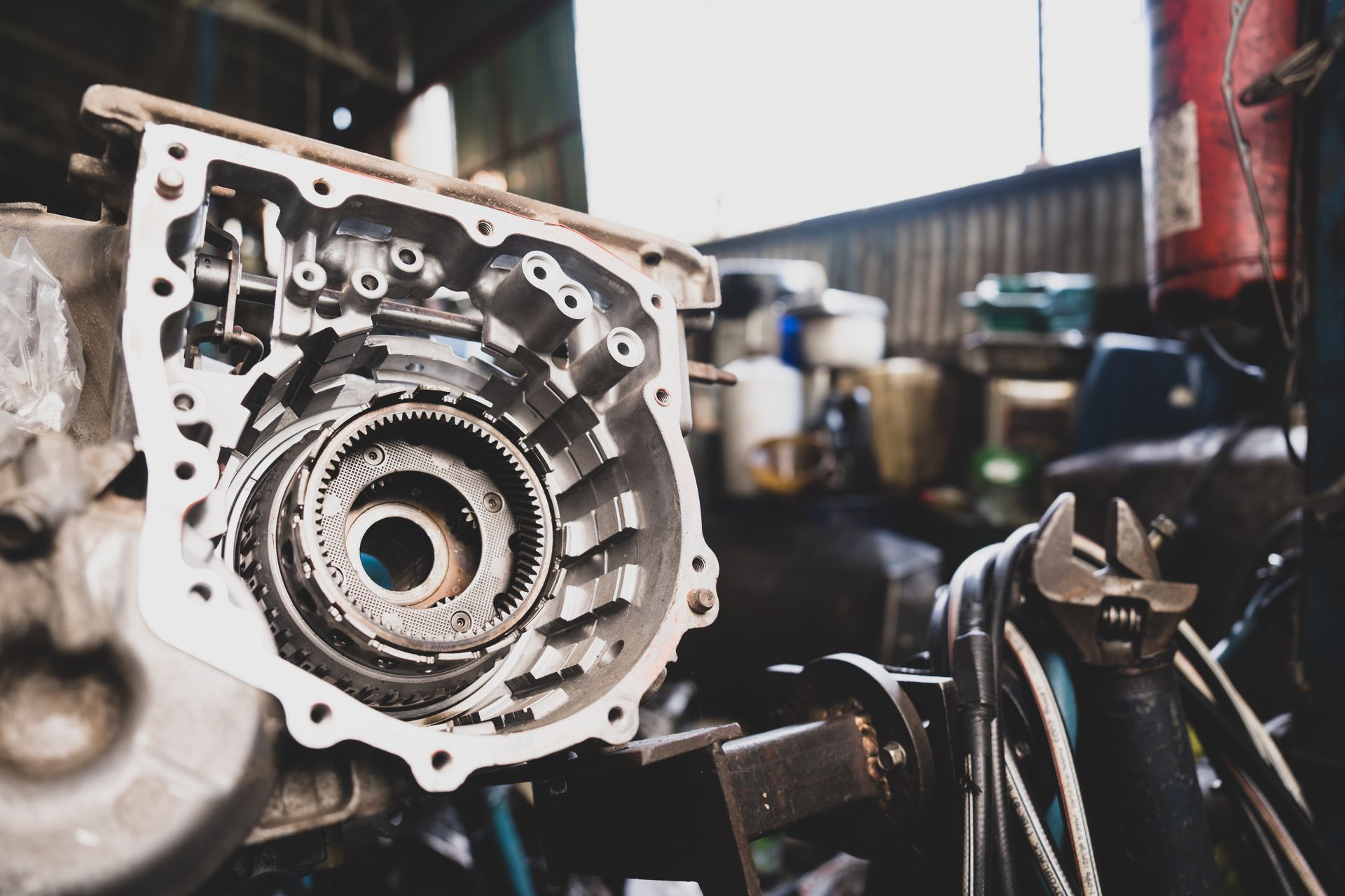 Open car transmission gears and housing, a wrench in an auto repair shop.