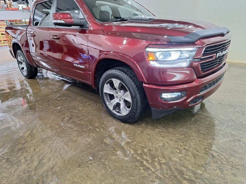A red ram 1500 truck is parked in a showroom.