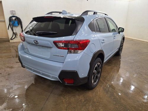 A blue subaru crosstrek is parked in a garage.