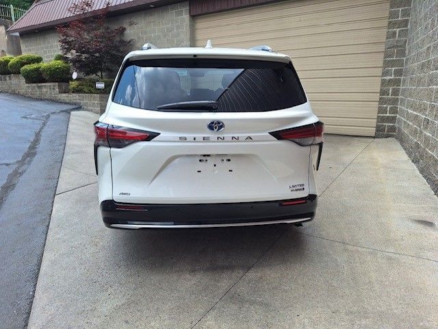 A white sienna is parked in front of a garage door