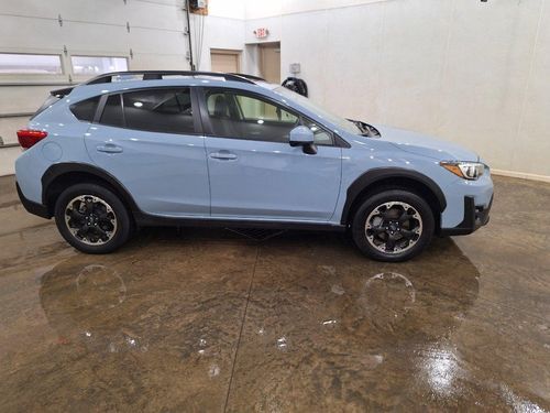 A blue subaru xv is parked in a garage.