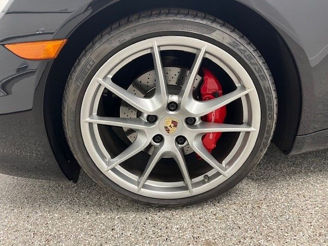 A close up of a car wheel with a red brake caliper.