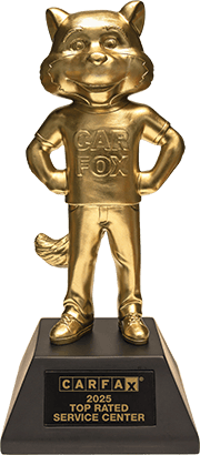 Gold CARFAX fox mascot trophy on a black base labeled “Top Rated Service Center”