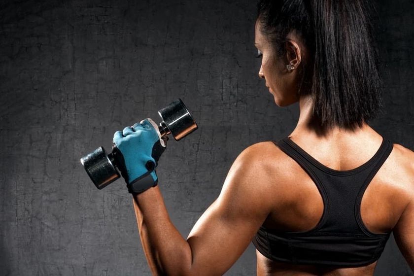 a woman is holding two red dumbbells in her hands 