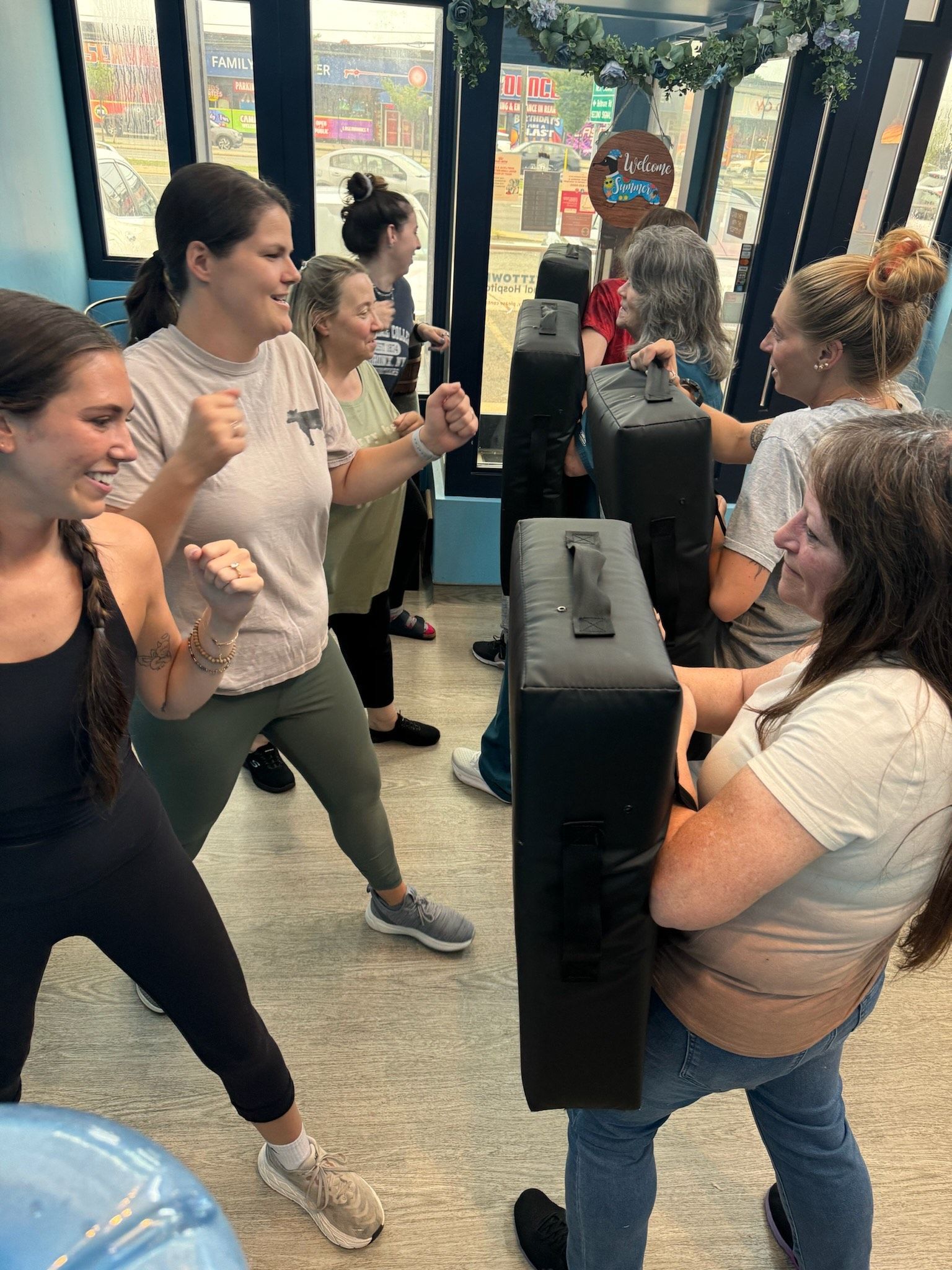 A group of women are practicing martial arts in a gym.