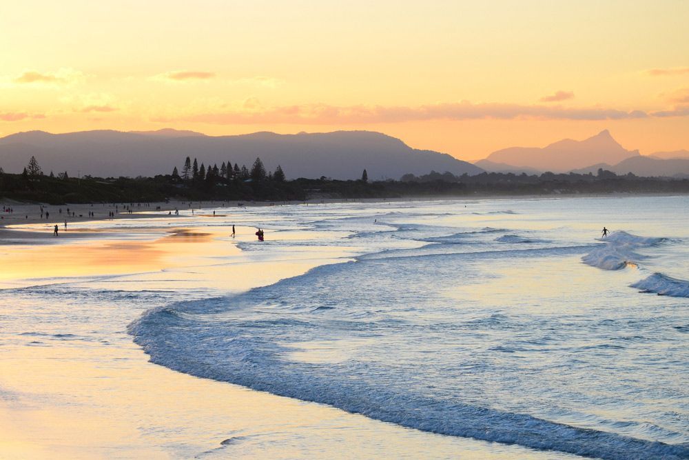 A Beach at Sunset with Mountains in The Background — Hager Surveying In Byron Bay, NSW