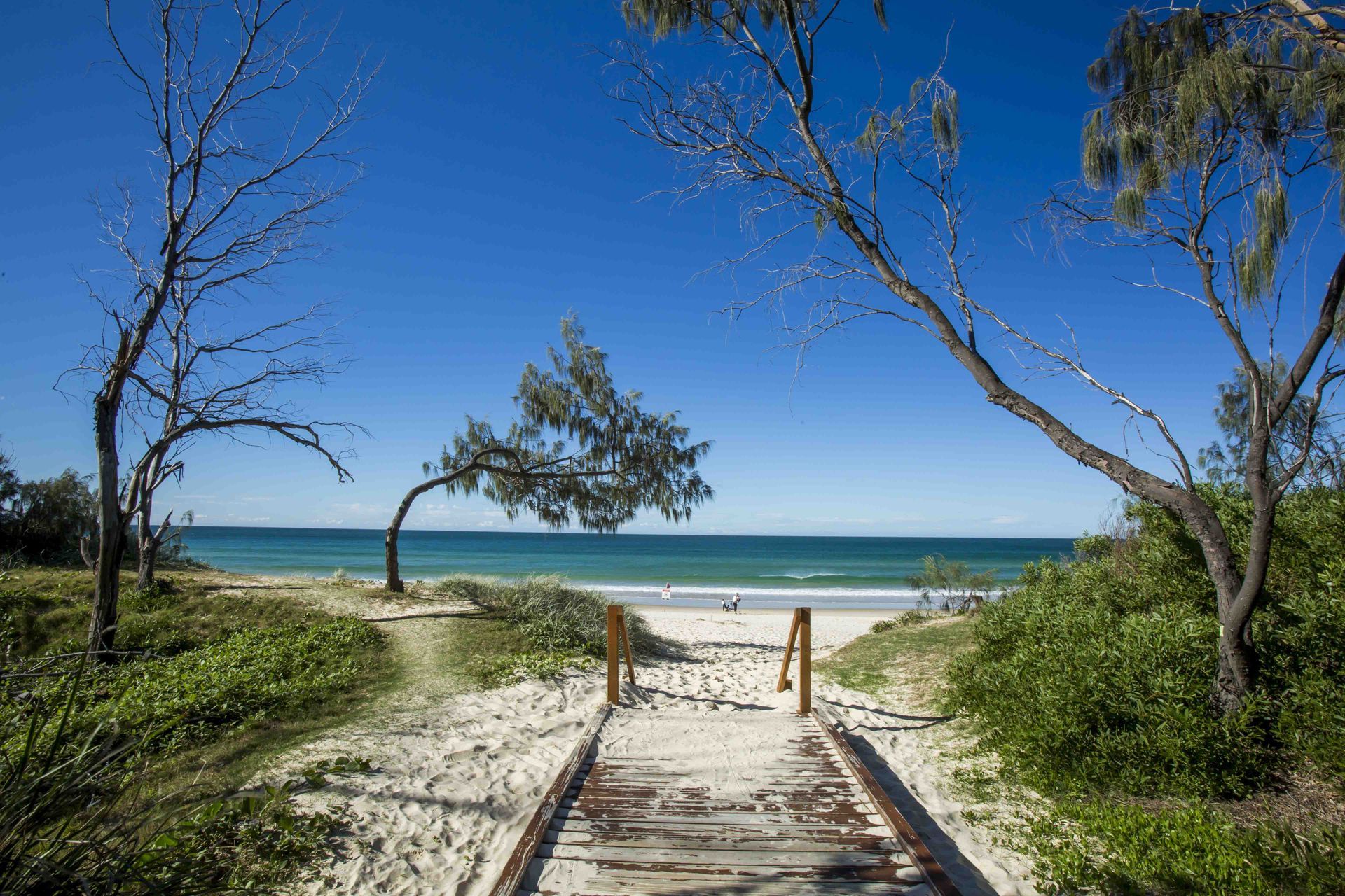 A Man and Woman Are Swimming in An Infinity Pool — Hager Surveying In Palm Beach, QLD
