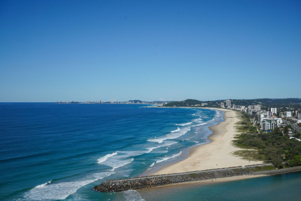 An Aerial View of A Beach with A City in The Background — Hager Surveying In Burleigh Heads, QLD