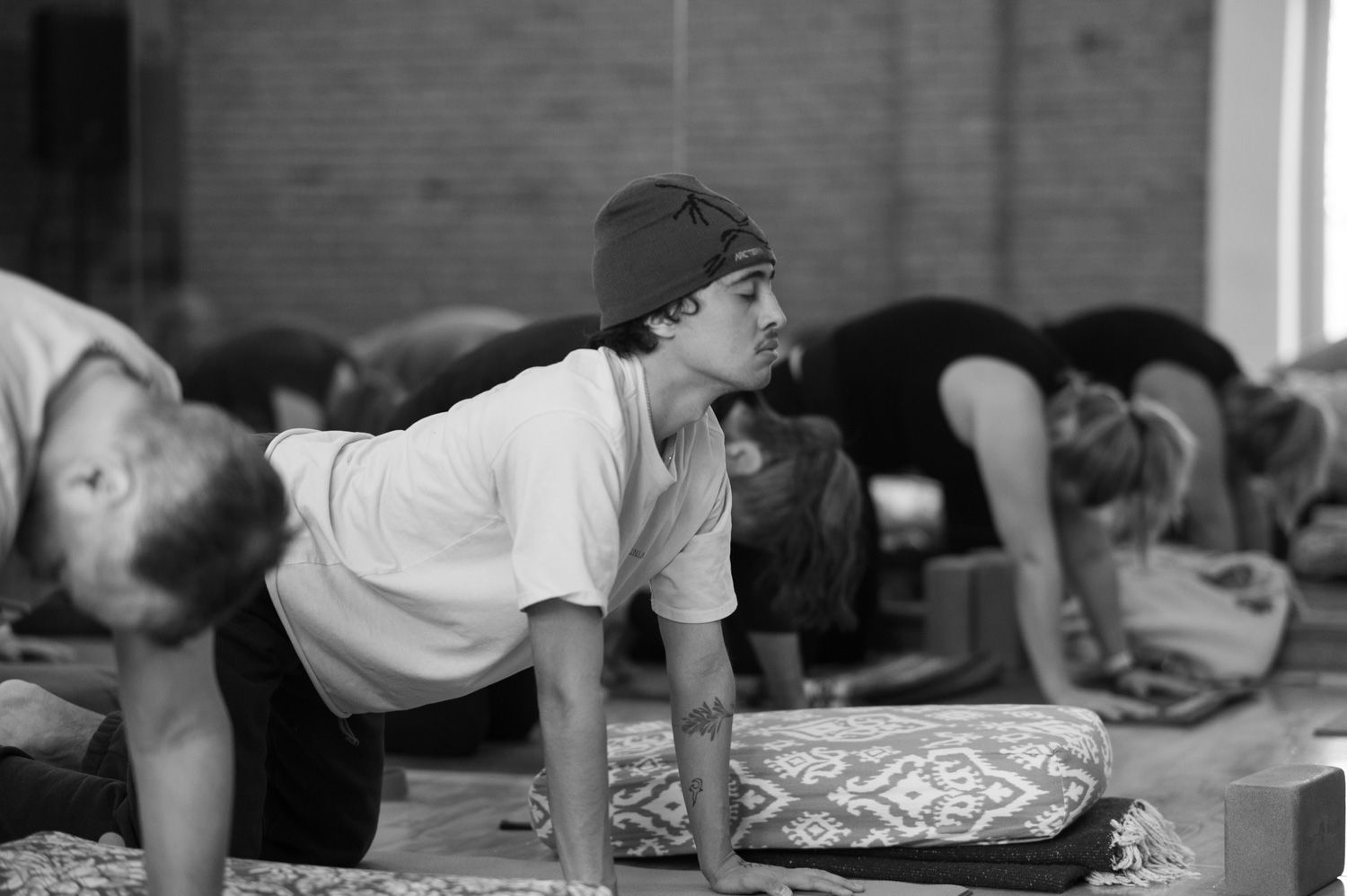 A black and white photo of a group of people doing yoga.