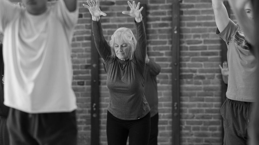 A black and white photo of a person 's feet and hands on a yoga mat.