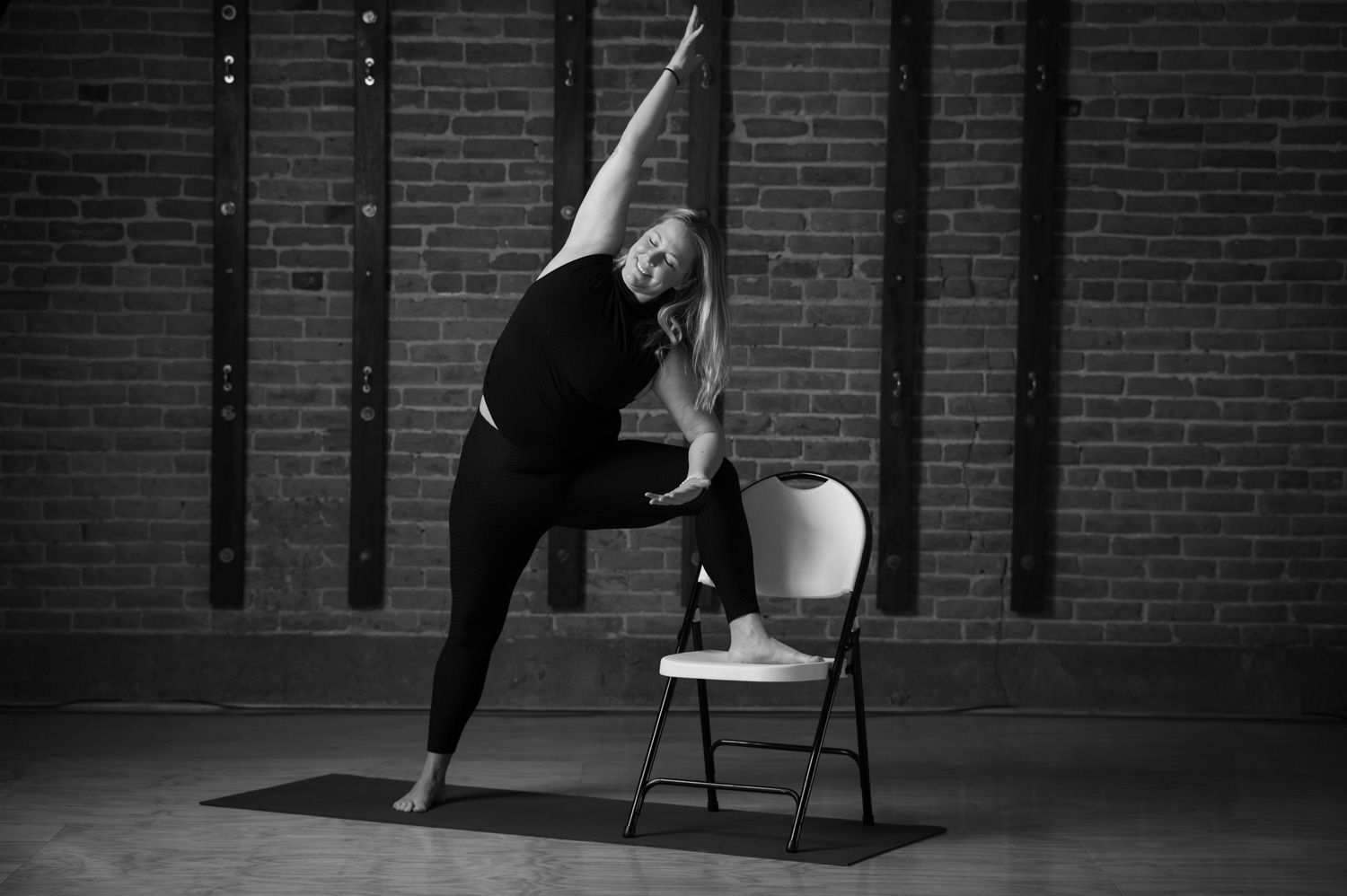 A person is sitting on a rug with their hands folded in prayer.