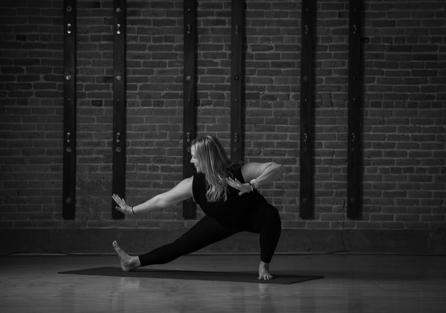 A black and white photo of a person 's feet and hands on a yoga mat.