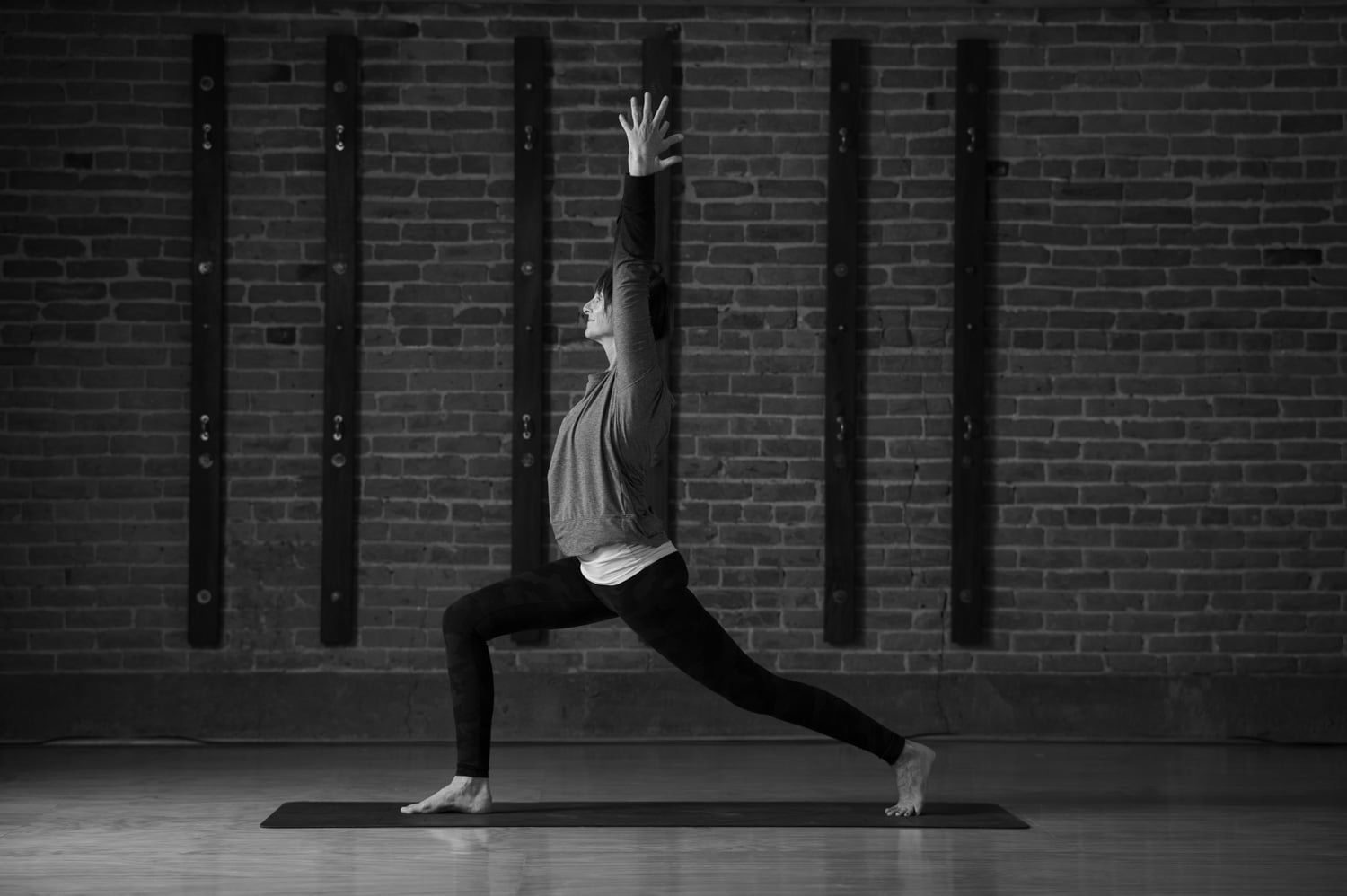 A group of people are doing yoga together in a black and white photo.