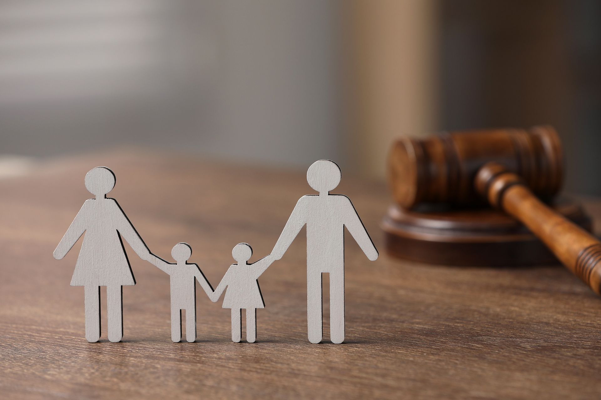 Wooden family figures with gavel, symbolizing family law or legal proceedings.