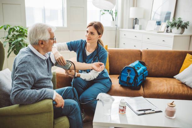 A nurse offering in-home nursing care to a senior patient.