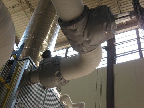 A large pipe is hanging from the ceiling of a building.