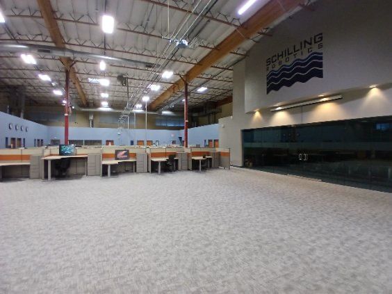 A large room with cubicles and a sign that says bowling alley