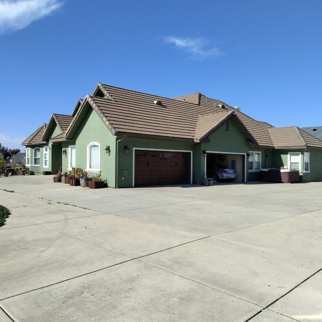 A large green house with a brown roof