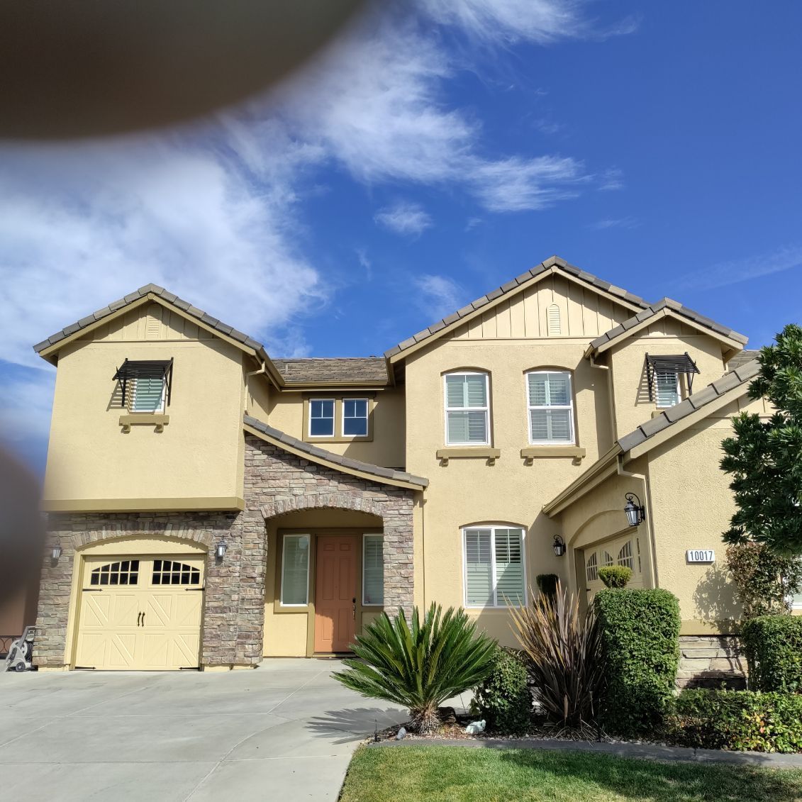 A large house with a blue sky in the background
