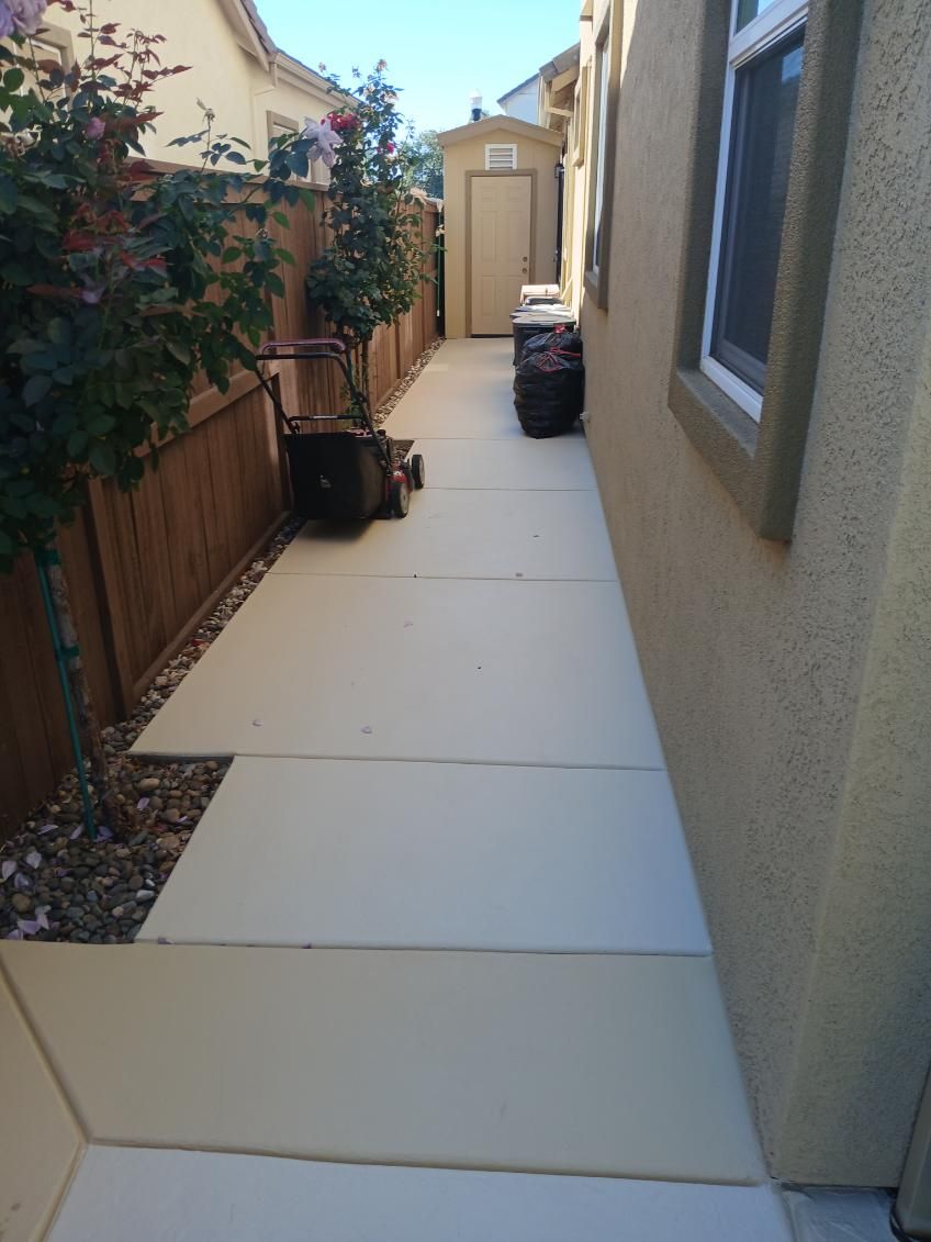 A sidewalk leading to a house with a shed in the backyard.