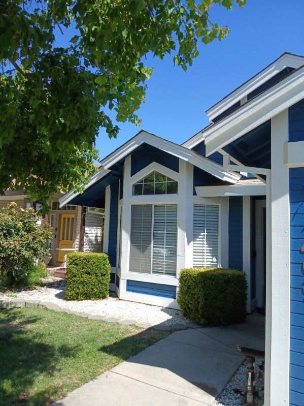 A blue and white house with a blue roof