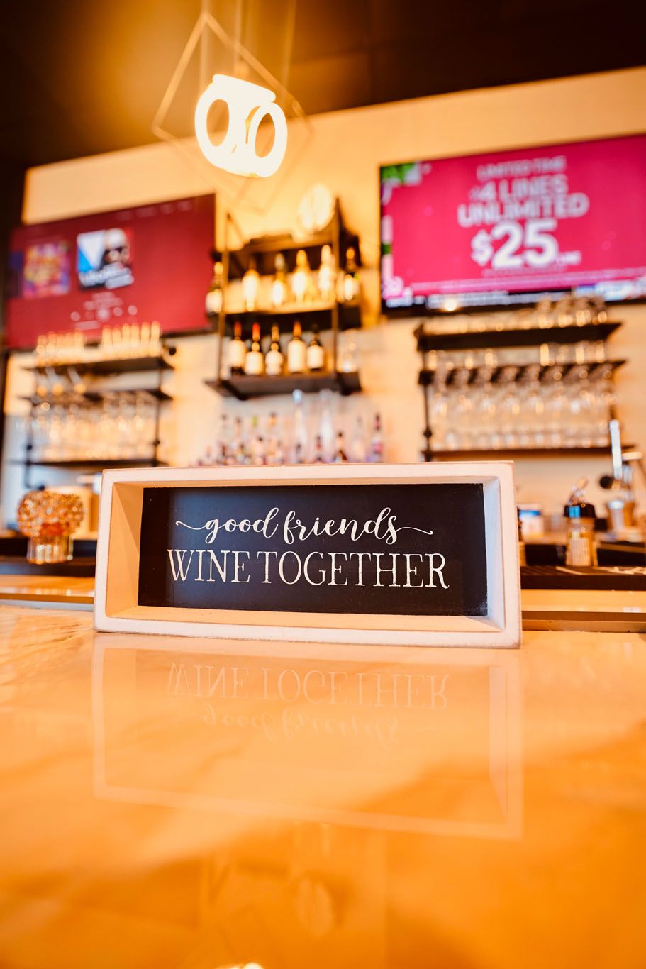 A sign on a bar says `` good friends wine together ''.