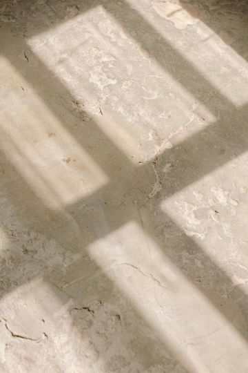 A shadow of a window is cast on a concrete floor.