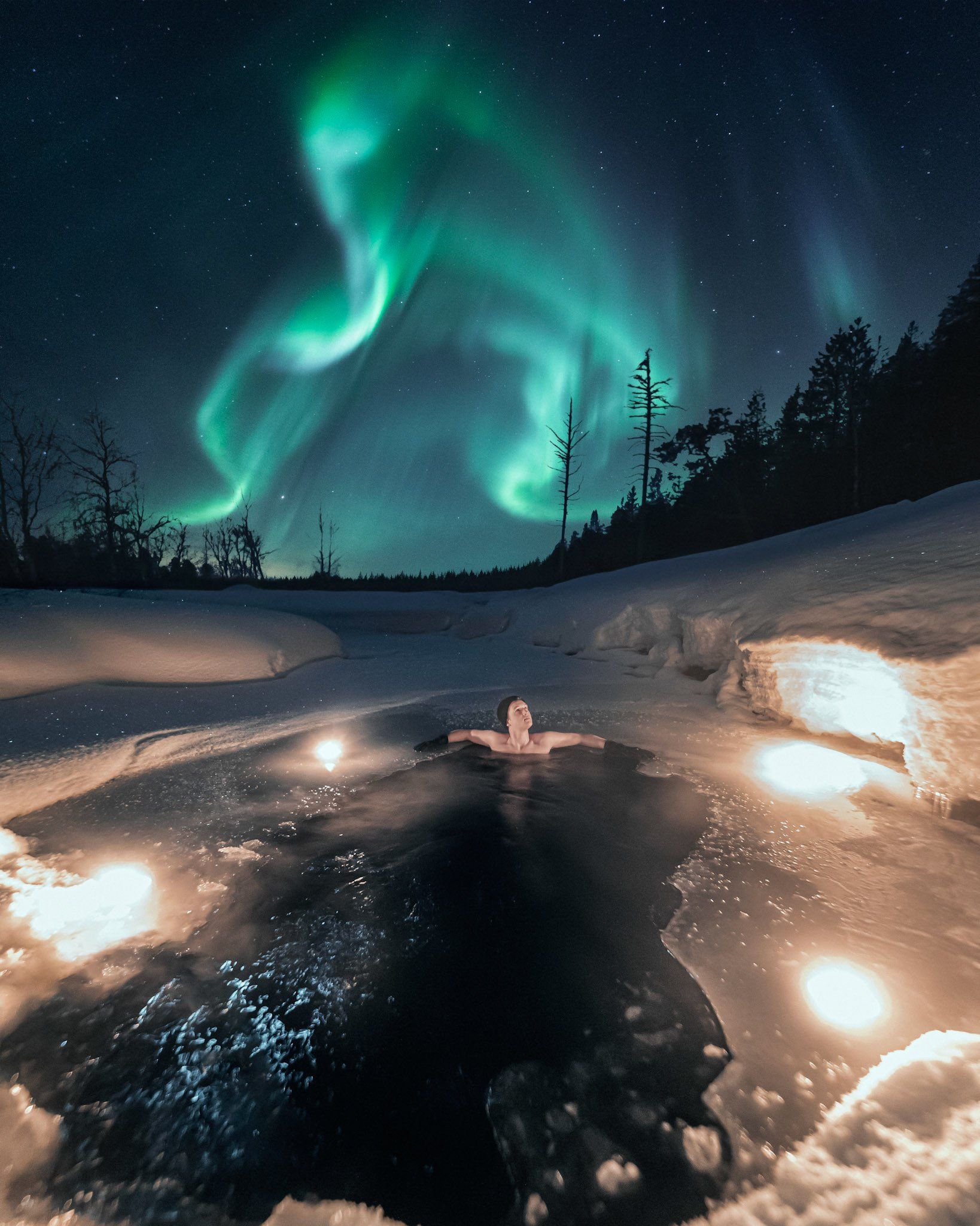 Dippen in een ijswak in Lapland onder het Noorderlicht