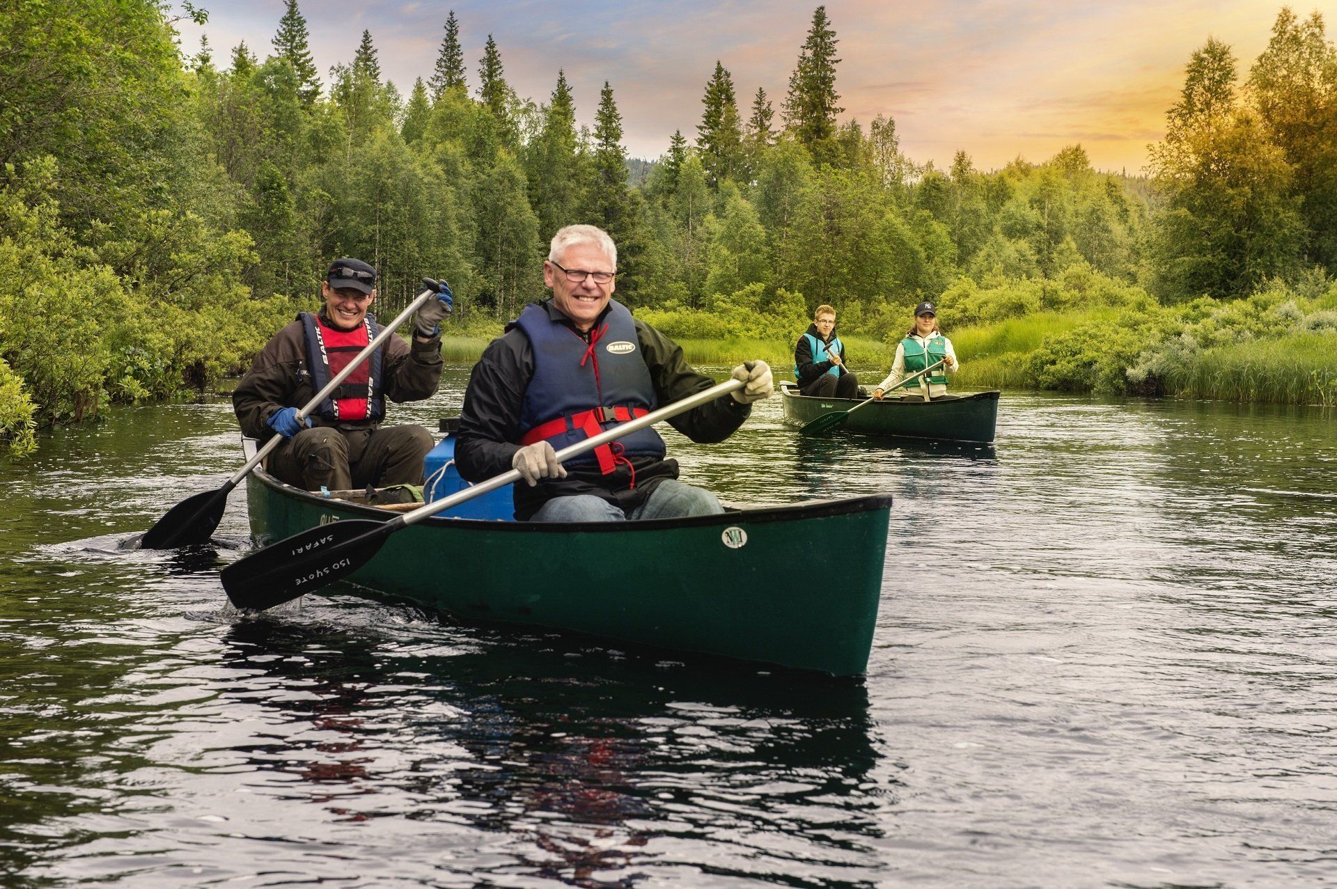 Een groep mensen roeit kano's over een rivier.