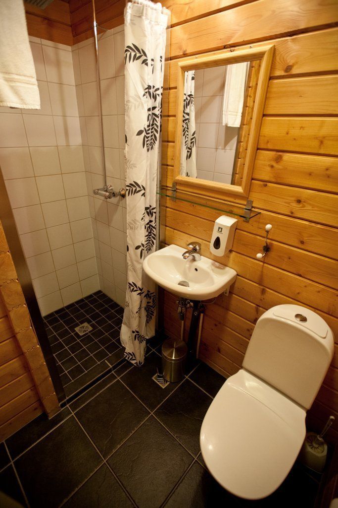 Een badkamer met toilet, wastafel en douche.